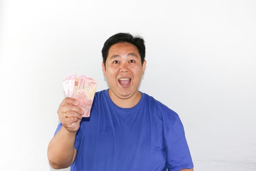 A man holding up a pink piece of paper photo