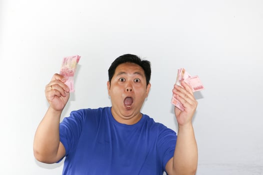 A man holding up two pink bills photo