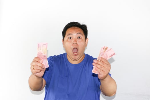 Asian man holding money in front of his face photo