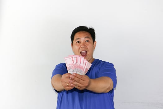 A man holding up a stack of money photo