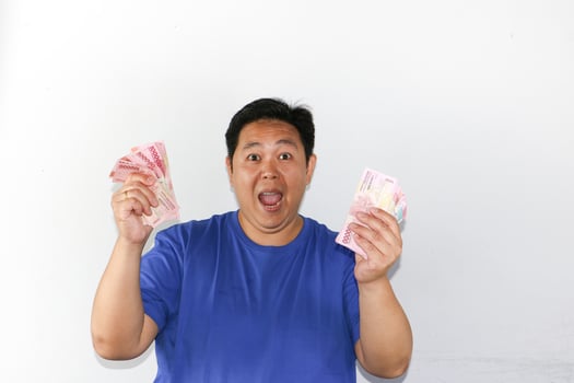 Asian man holding money in front of white background photo