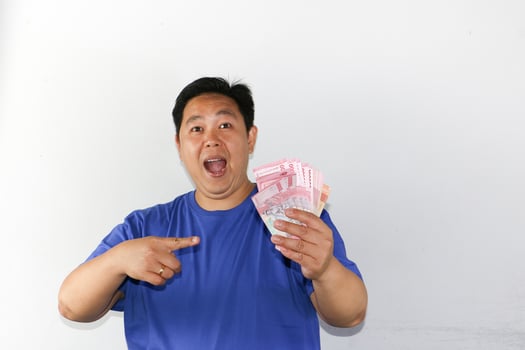 A man holding up money and pointing at something photo