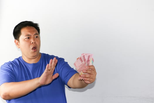 A man holding up a piece of money photo
