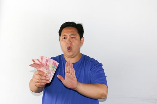 A man holding up money in front of a white background photo