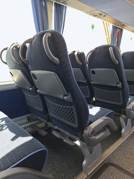 Empty bus interior with modern blue reclining seats and tray tables photo