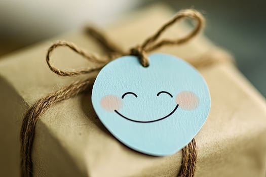 Package wrapped in paper and tied with a string with a happy face tag photo