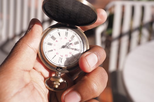 Pocket watch held in hand during sunny afternoon photo
