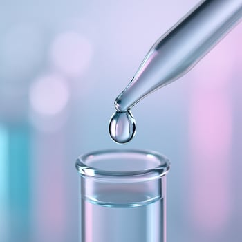 A glass test tube with liquid being poured into it photo