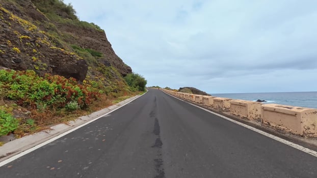 A picturesque coastal road gracefully winding alongside a stunning rocky landscape and breathtaking ocean view photo