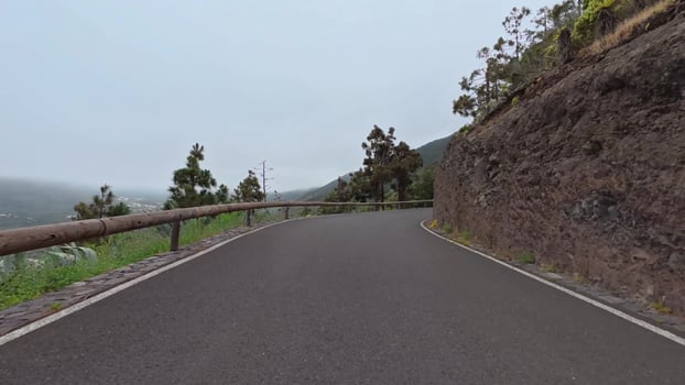 A beautiful winding road among rocky cliffs and vibrant vegetation, ideal for nature lovers to explore photo