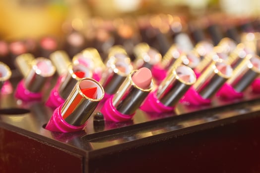 Array of lipstick sticks in various shades housed in golden casings photo