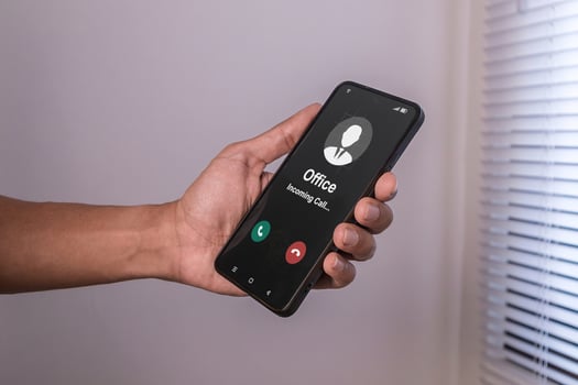A man's hand holding smartphone with incoming call from office at night after business hours. Right to disconnect concept. photo