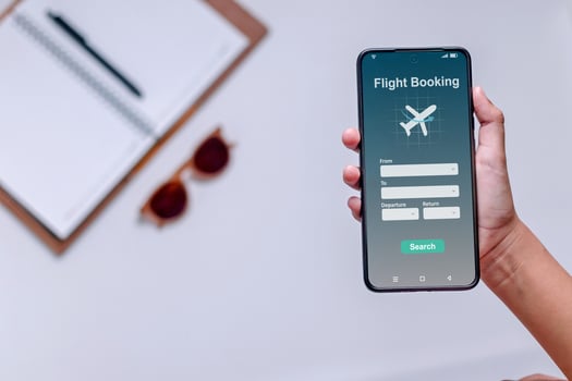 Online ticket booking concept. Hand holding a smartphone with airline ticket booking application on screen. photo