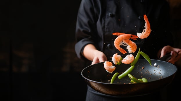 Chef preparing a colorful shrimp dish with vibrant vegetables, showcasing culinary skill and creativity. photo