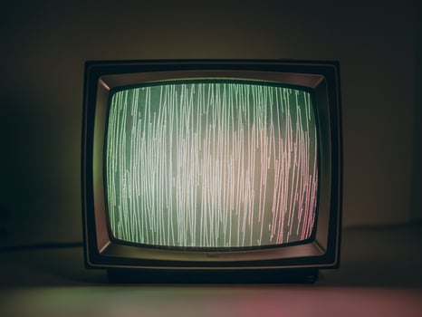 An old television screen displaying vibrant green static noise in a retro setting. photo