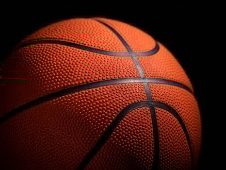 Close-up of a textured basketball against a dark background, highlighting its surface and design. photo