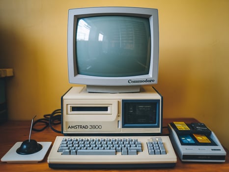 Vintage computer setup featuring an Amstrad 3800 with a monitor, keyboard, and cassette drive. photo