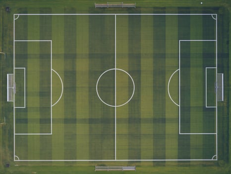 Aerial view of a vibrant green soccer field with crisp white lines and goals on either side. photo