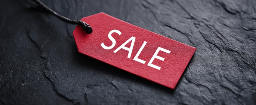 The sale tag showcasing bold red color on textured black background photo