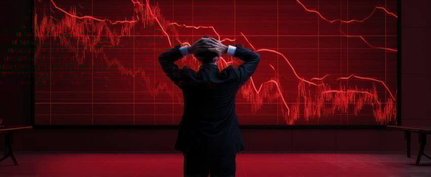 The businessman observing a declining stock market graph with concern and anxiety. photo