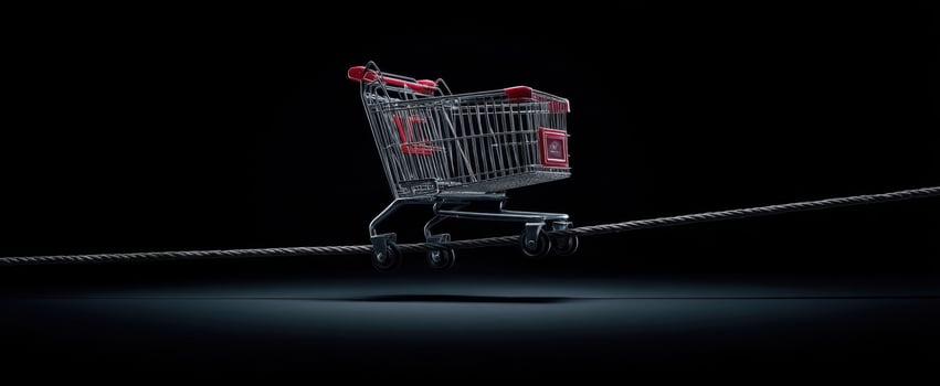 The shopping cart balancing on a rope against a dark background. photo