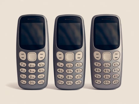 Three classic mobile phones lined up, showcasing retro design and simplicity. photo