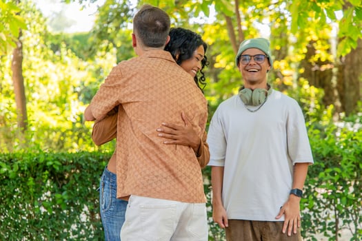 Multicultural friends hugging in the park during a picnic photo