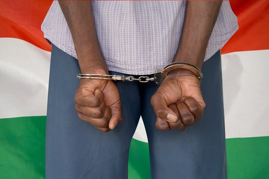 Black male with handcuffs on the background of the Hungary flag photo