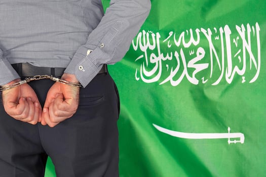 Male with handcuffs on the background of the Saudi arabia flag photo