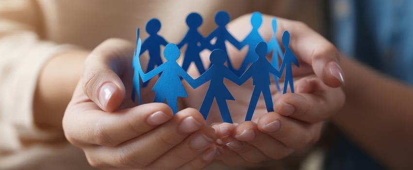 The hands holding blue paper cutouts symbolizing unity and community support photo