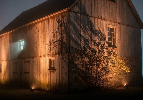 Mysterious Old Wooden Barn Illuminated at Night with Dramatic Shadows photo