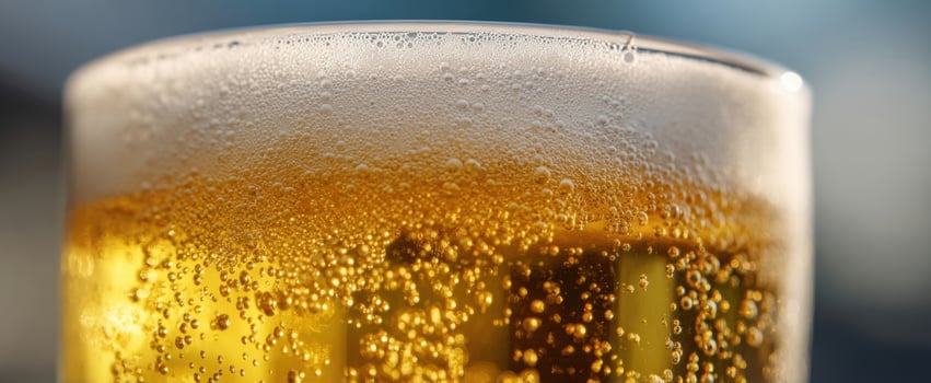 The shimmering golden beer in a frosty glass with bubbles. photo