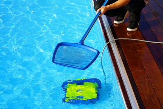 Hotel staff worker cleaning the pool. Automatic pool cleaners photo
