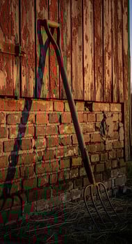 Rustic Pitchfork Leaning Against Weathered Barn Wall and Brick photo