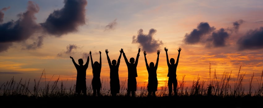 The silhouetted group celebrating life against a vibrant sunset backdrop. photo