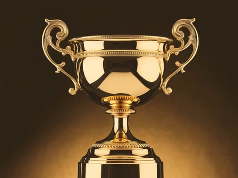 Shiny golden trophy with elegant design illuminated against a dark background. photo