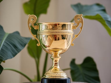 Shiny golden trophy with ornate handles, symbolizing achievement and success. photo