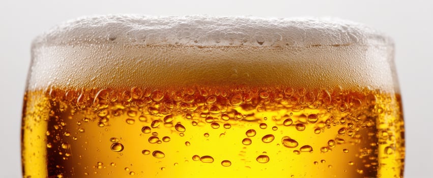 The close-up view of a frothy beer in an elegant glass. photo