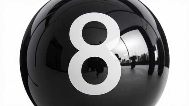 A close-up of a glossy black pool ball with the number eight displayed prominently. photo