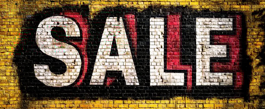 The vibrant graffiti art showcasing a bold SALE message on a brick wall photo