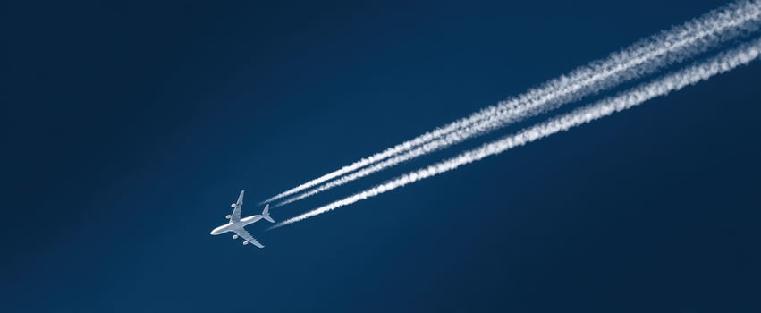The airplane glides through a clear blue sky leaving white contrails behind. photo