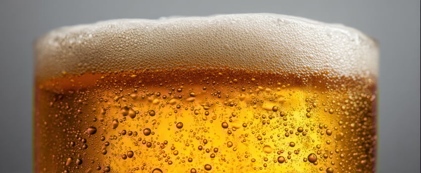 The golden glass of beer with frothy foam and bubbles sparkling. photo