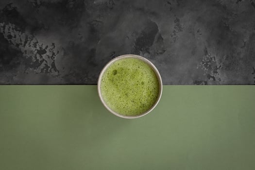 Matcha green tea latte in a cup on a gray and green background photo