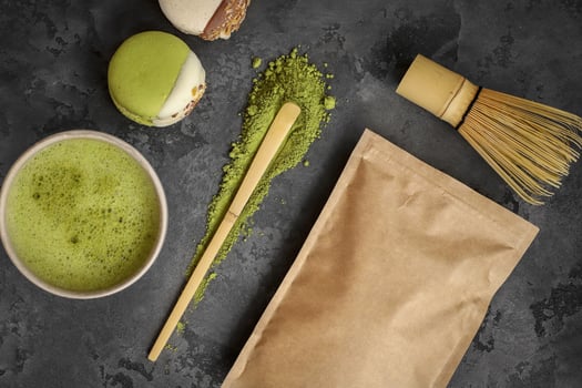 Matcha green tea with macaroons and matcha powder on dark background photo