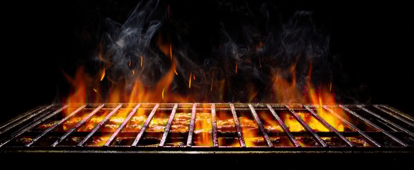 The grill ignites with vibrant flames and tantalizing smoke during cooking. photo