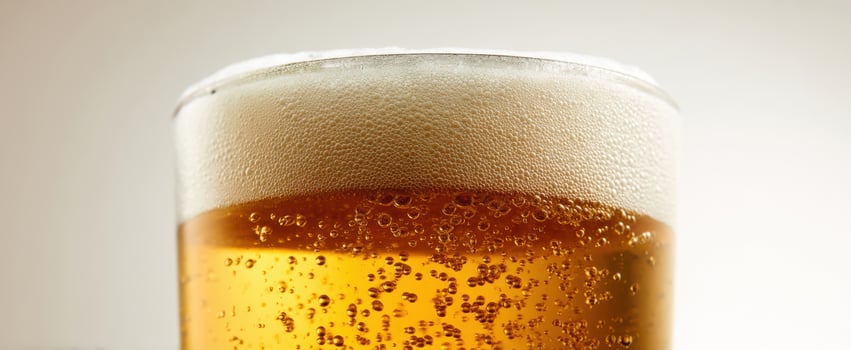 The frothy beer in a cold glass with bubbles and inviting amber color photo