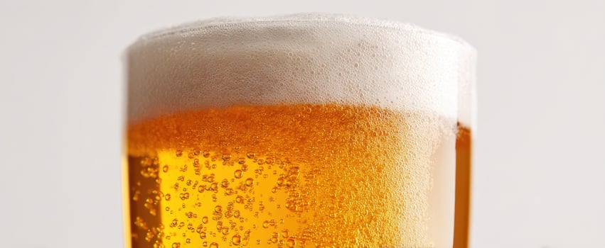 The refreshing golden beer with frothy head in a clear glass. photo