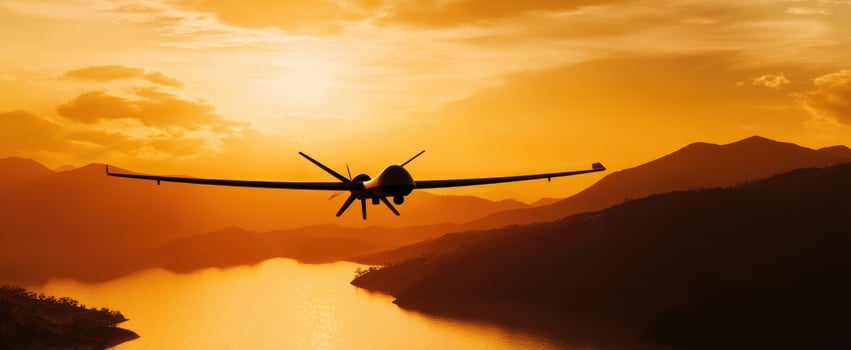 The Drone Gliding Over a Serene Sunset Landscape with Mountains and Water photo
