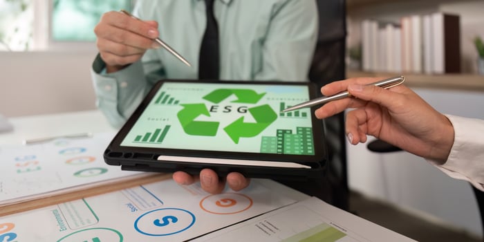 ESG Metrics Review. Team analyzing environmental and social governance data on tablet. photo