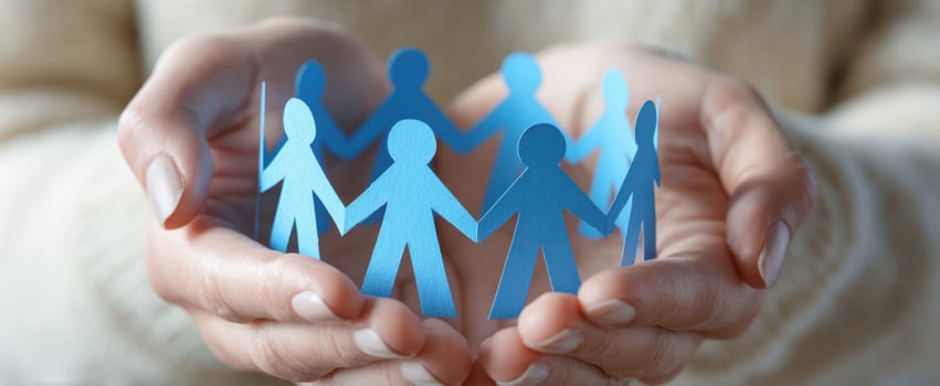 The hands holding blue paper figures representing unity and community support. photo